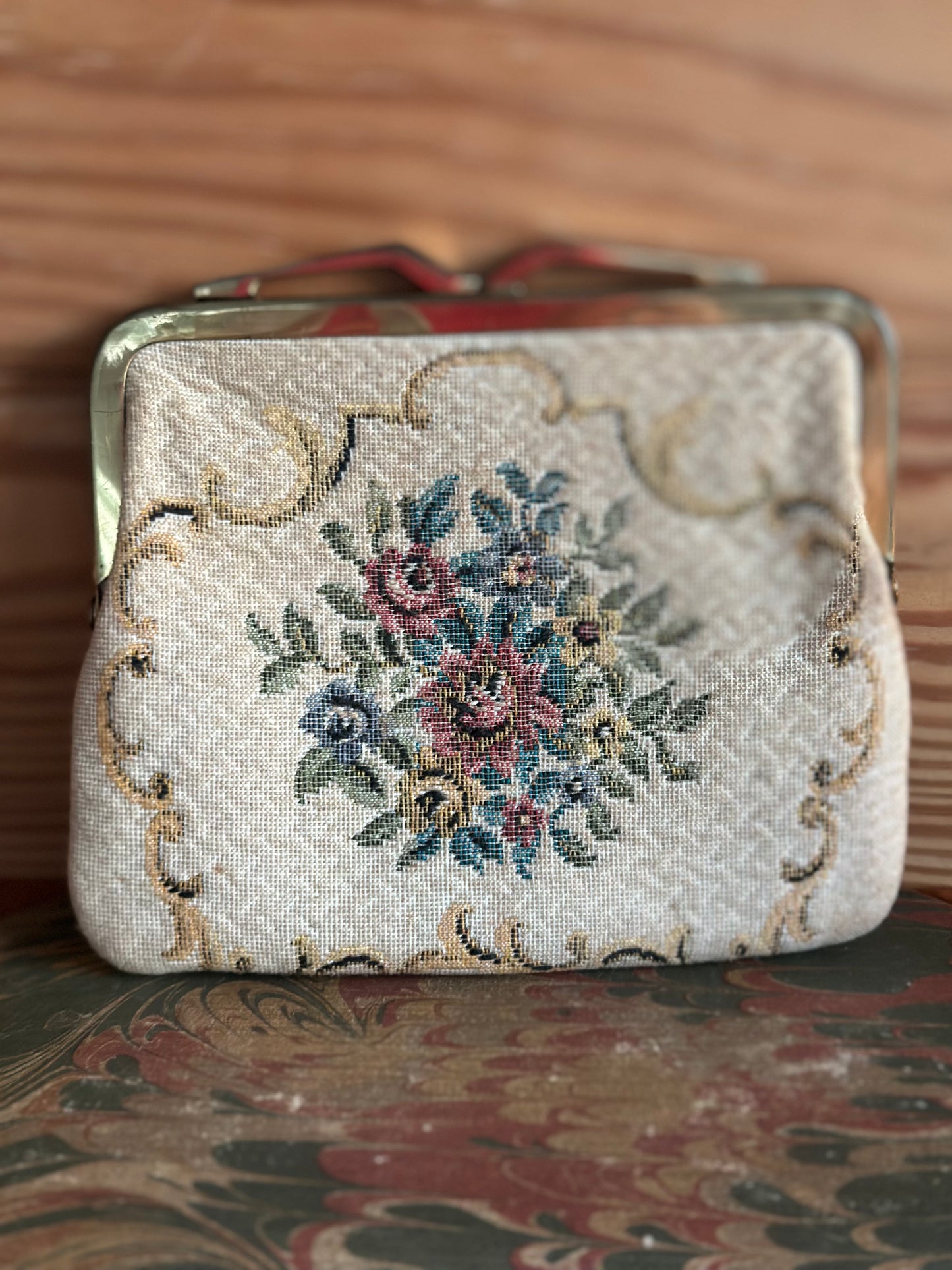 Retro floral tapestry coin purse from Neiman Marcus, 1950s, with a brass frame and delicate woven fabric, showcasing elegant vintage craftsmanship.