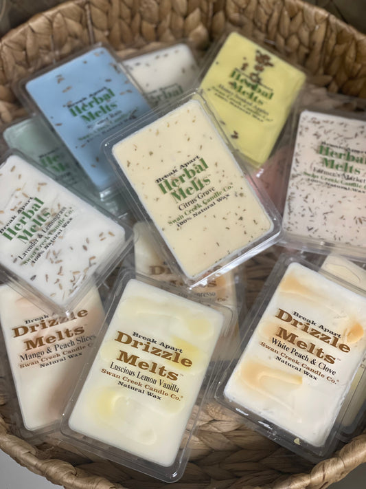 Assorted Swan Creek Herbal Melts candle wax cubes in a woven basket. Scented break-apart wax tarts for home fragrance in various aromas.