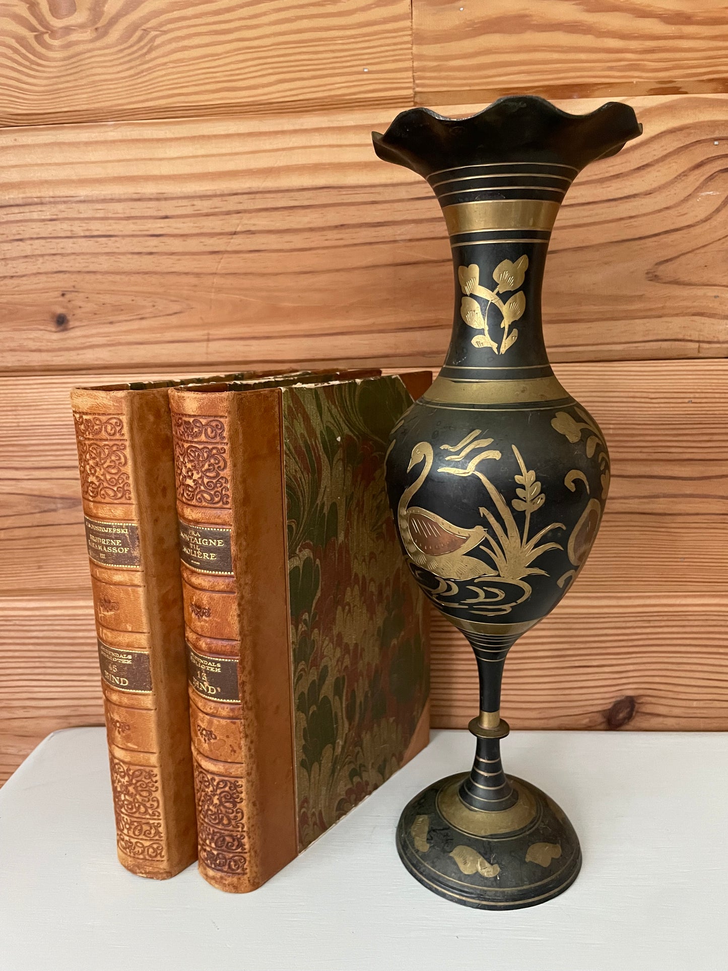 Vintage gold brass black urn with intricate etched swan design. Elegant home decor vase with fluted top, perfect for adding a classic touch.