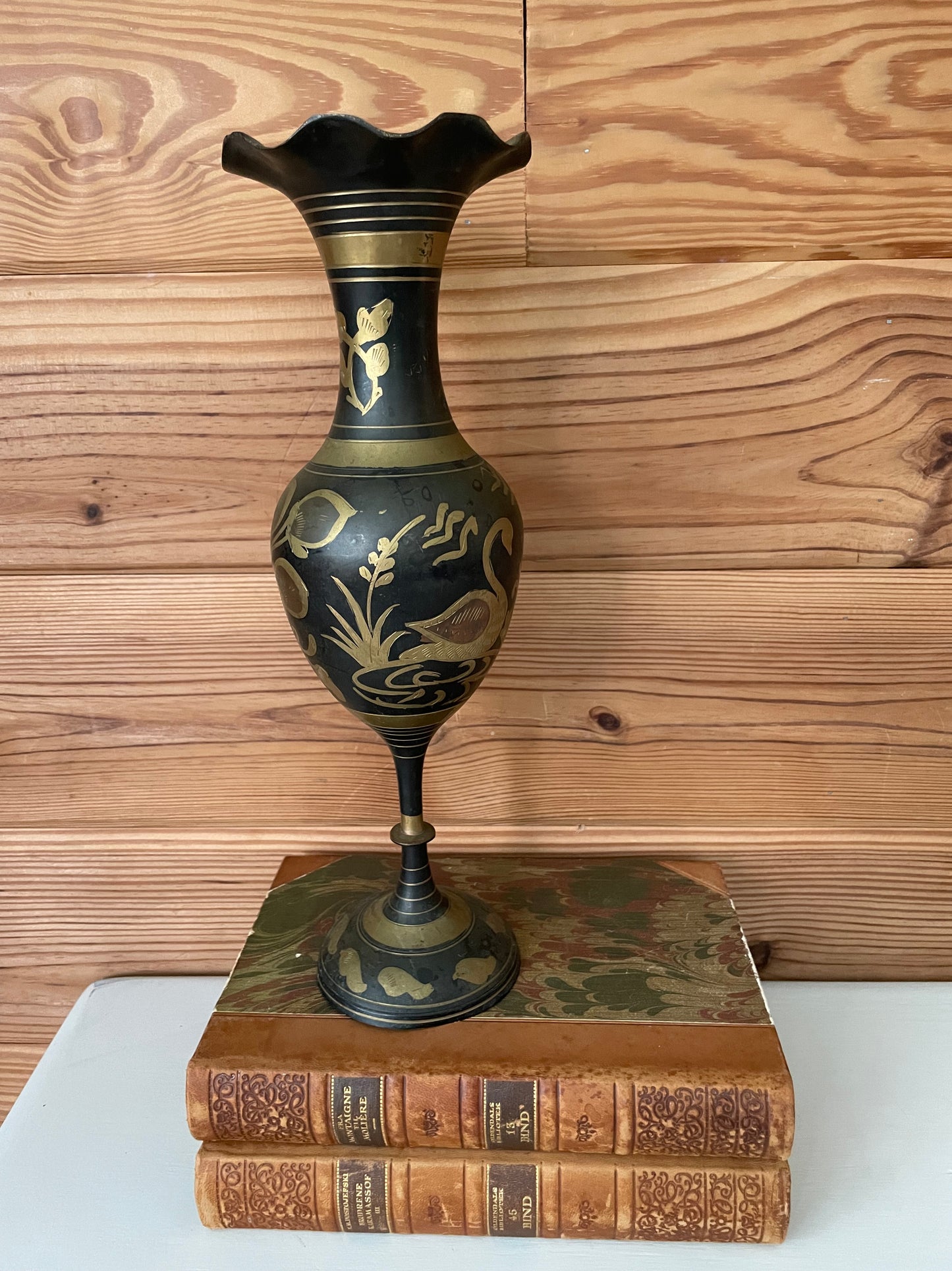 Antique-style black brass urn with gold etching featuring swan motifs. Decorative vintage vase ideal for home and garden decor.