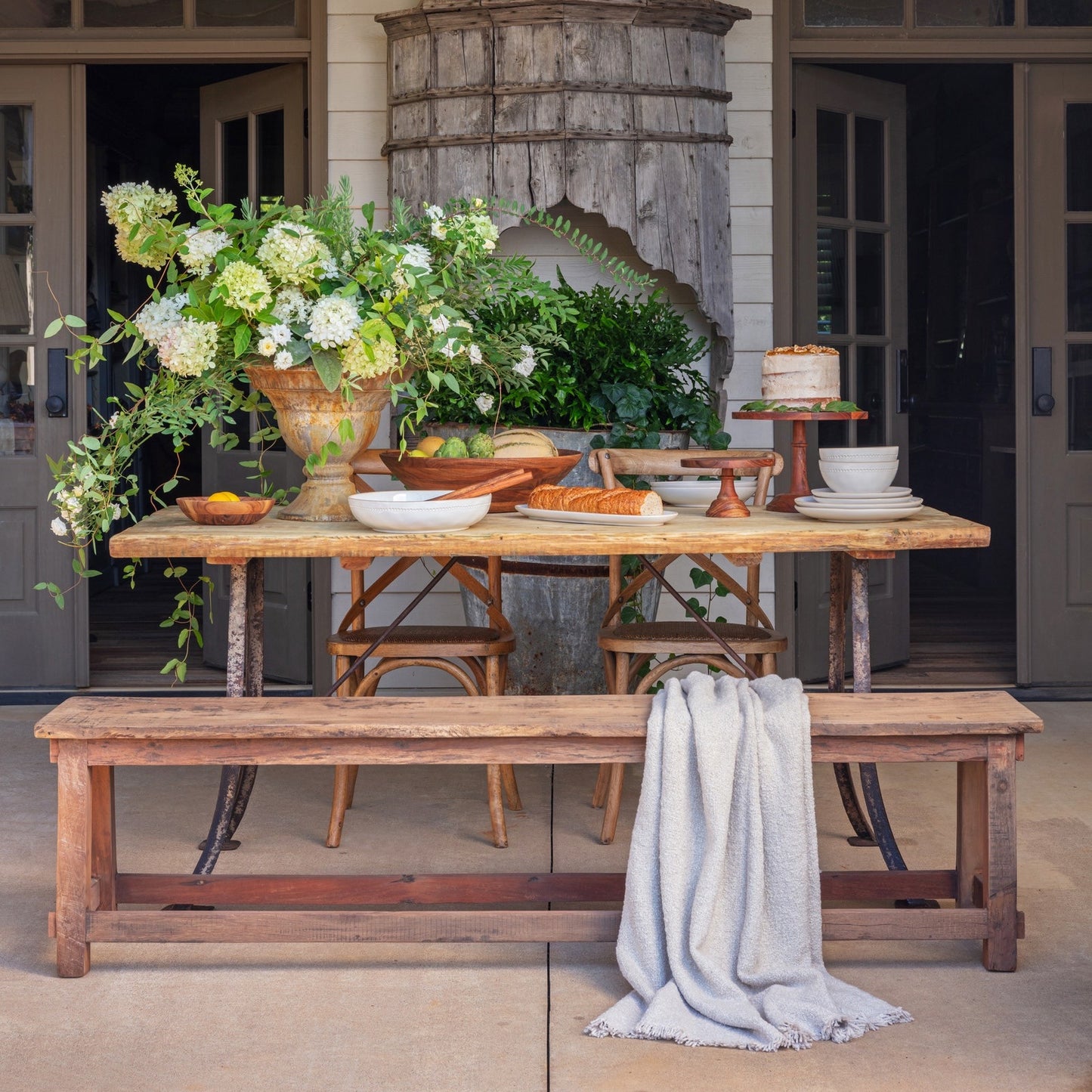 Beautifully styled dining table with a small wooden cake stand, showcasing a rustic yet modern aesthetic. Ideal for elegant dessert displays.