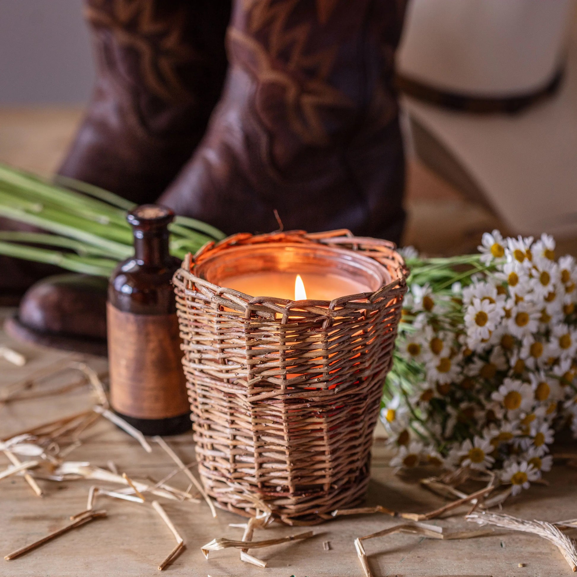 Porch View Home Cowgirl Candle with vanilla and leather scent in a woven rattan holder. Warm ambiance with rustic decor, perfect for home fragrance.