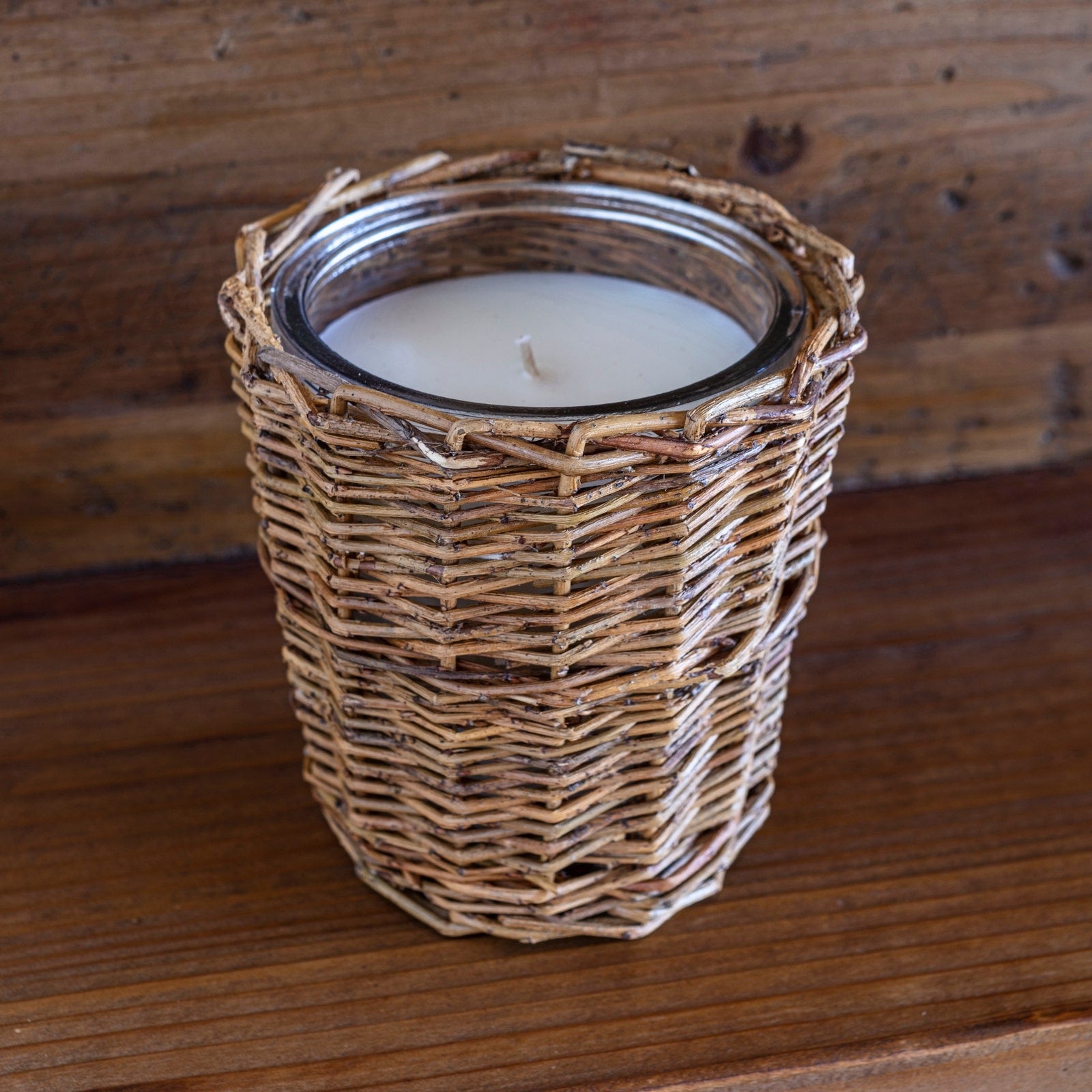 Porch View Home Cowgirl Candle in a glass jar wrapped with woven rattan. Natural wax with vanilla leather scent, ideal for cozy home decor.