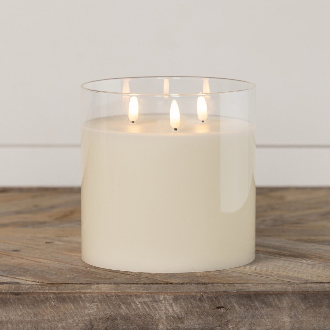 Glass 3 Wick 3D Flame Candle - 6-inch with lifelike flickering flames, placed on a wooden surface. A stylish and safe flameless candle for home decor.