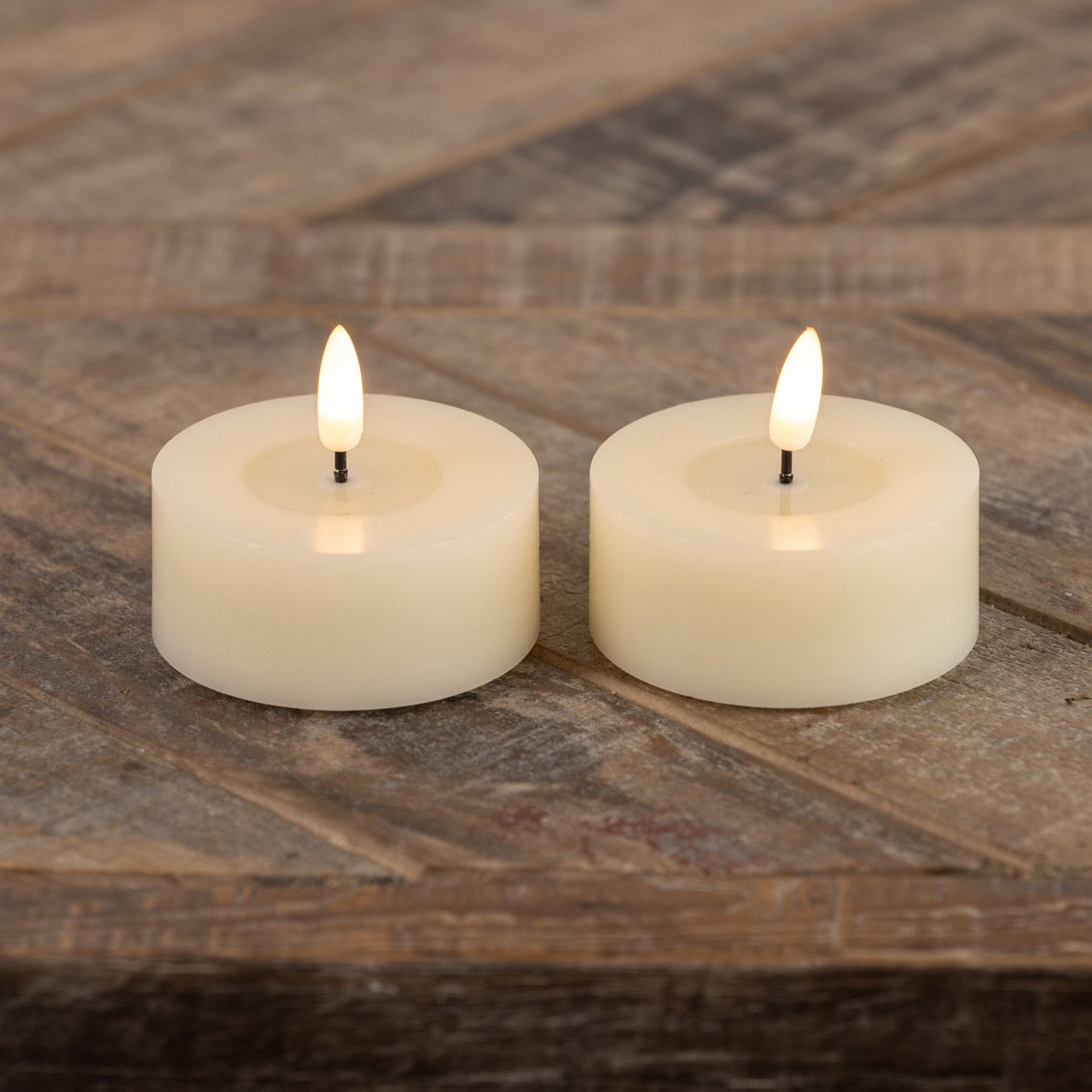 Set of 2 oversized tealight candles with a realistic 3D flame effect, placed on a rustic wooden surface. Perfect for home decor and ambiance.