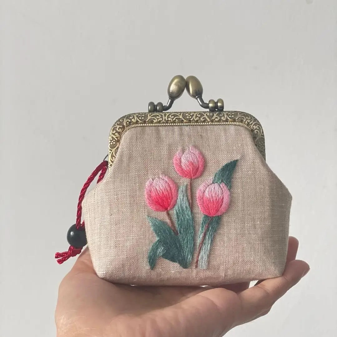 Tulip embroidered beige coin purse with vintage metal clasp and red string detail. Handmade linen pouch featuring pink tulip floral embroidery.