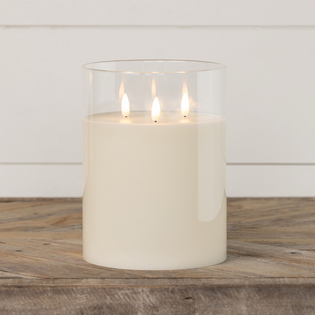 Glass 3 wick candle with a 3D flame effect on a wooden surface. A stylish home fragrance piece for cozy ambiance.