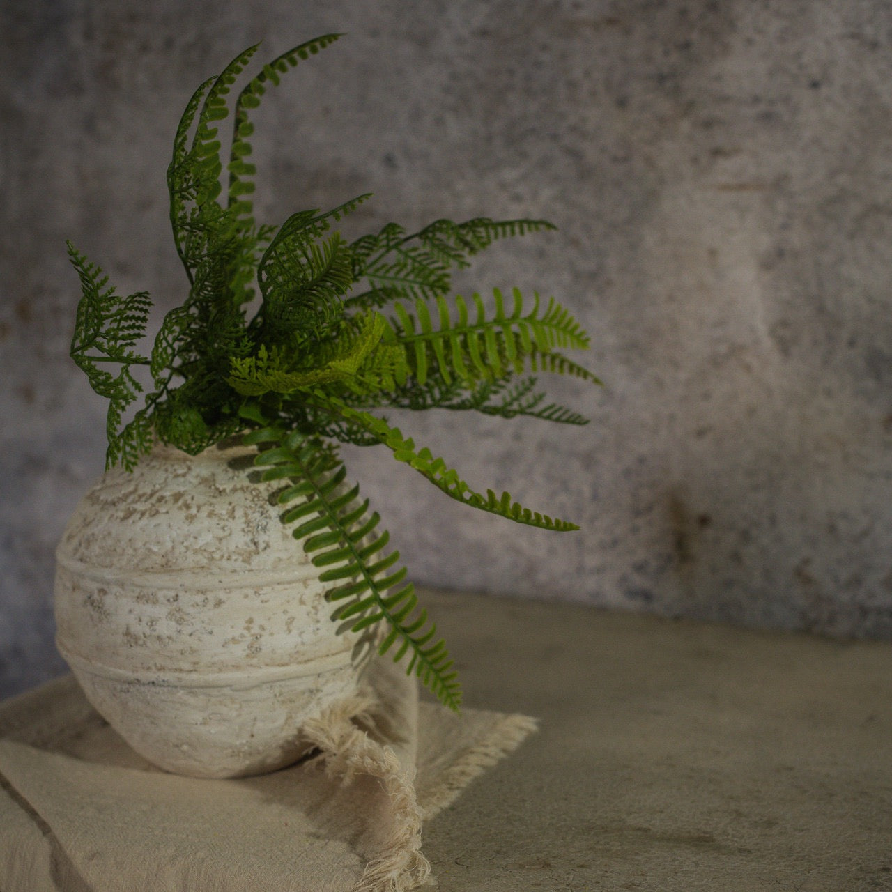 Realistic 12-inch Sword Fern & Cedar Bush arranged in a textured ceramic vase. A perfect artificial plant for elegant home styling.