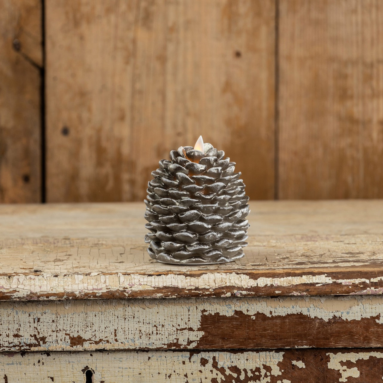 Moving Flame Pinecone Candle - 4.25" with a realistic flickering flame, featuring a textured pinecone design in a rustic setting.