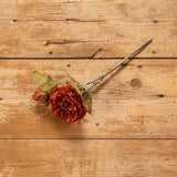 14" Burnt Orange Rose Pick with green leaves on a wooden surface. Ideal for floral arrangements, home decor, and seasonal decorations.