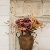 19" Sage Purple Peony Spray in a rustic vase with golden foliage. Lifelike artificial flowers enhance any home or seasonal decor setting.