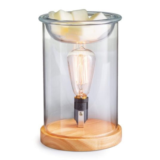 Wood and glass vintage bulb illumination fragrance warmer with a clear glass body, wooden base, and Edison-style bulb, melting wax cubes on top.