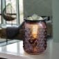 Smokey Hobnail Vintage Bulb Illumination Fragrance Warmer placed on a countertop, emitting a warm light while melting wax cubes.