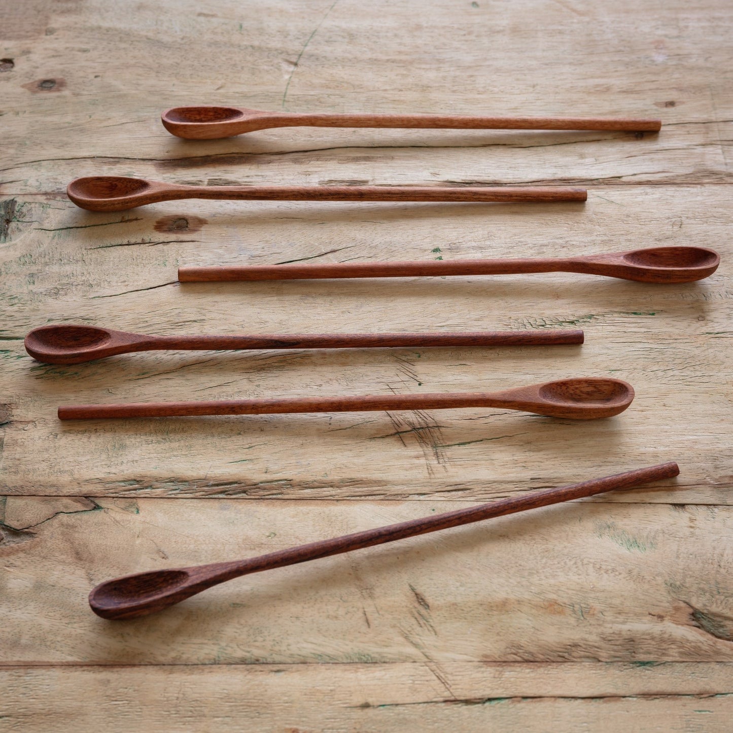 Handcrafted wooden ice tea spoons, set of 6, neatly arranged on a wooden background. Perfect for mixing drinks and serving in tall glasses.