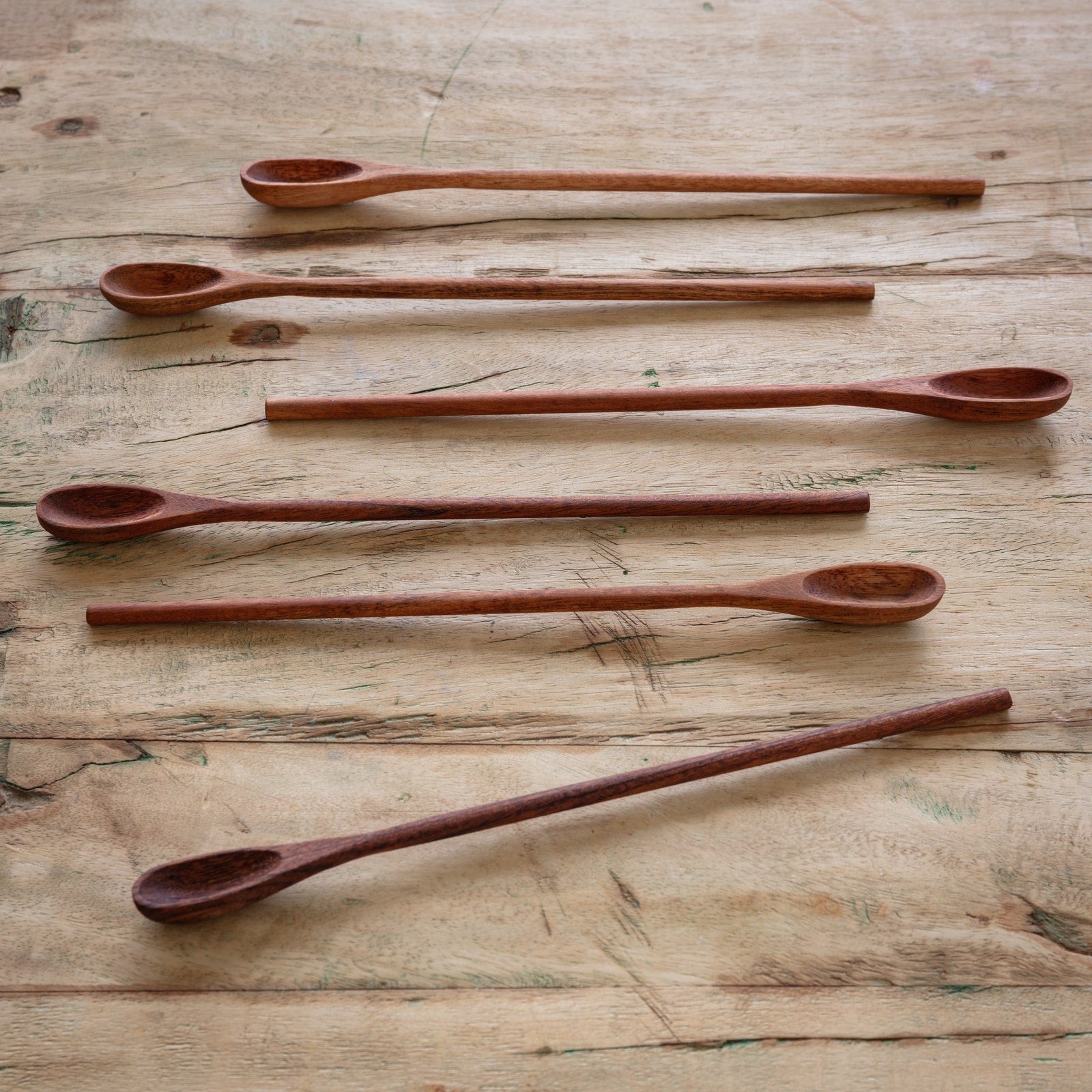 Handcrafted wooden ice tea spoons, set of 6, neatly arranged on a wooden background. Perfect for mixing drinks and serving in tall glasses.