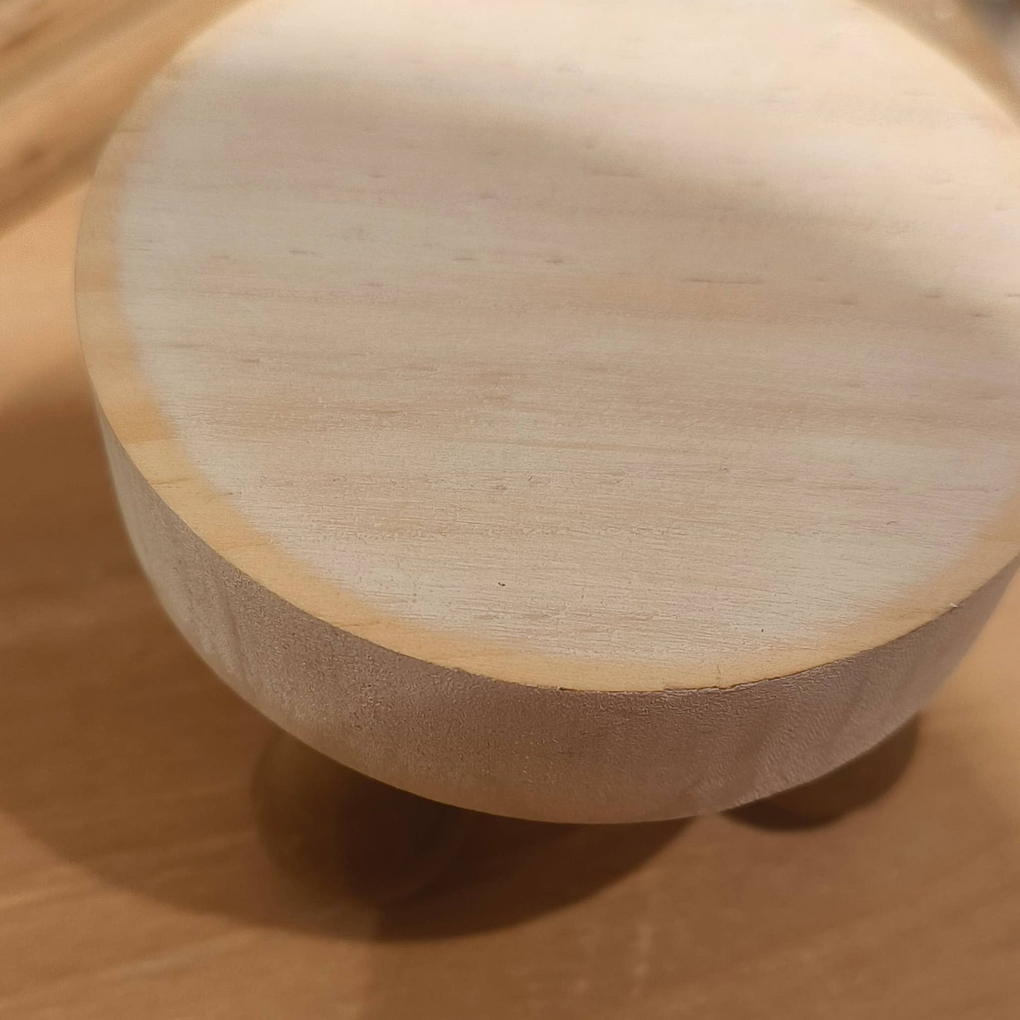 Top view of a round white wooden display riser with a smooth surface, ideal for showcasing small decorative items.