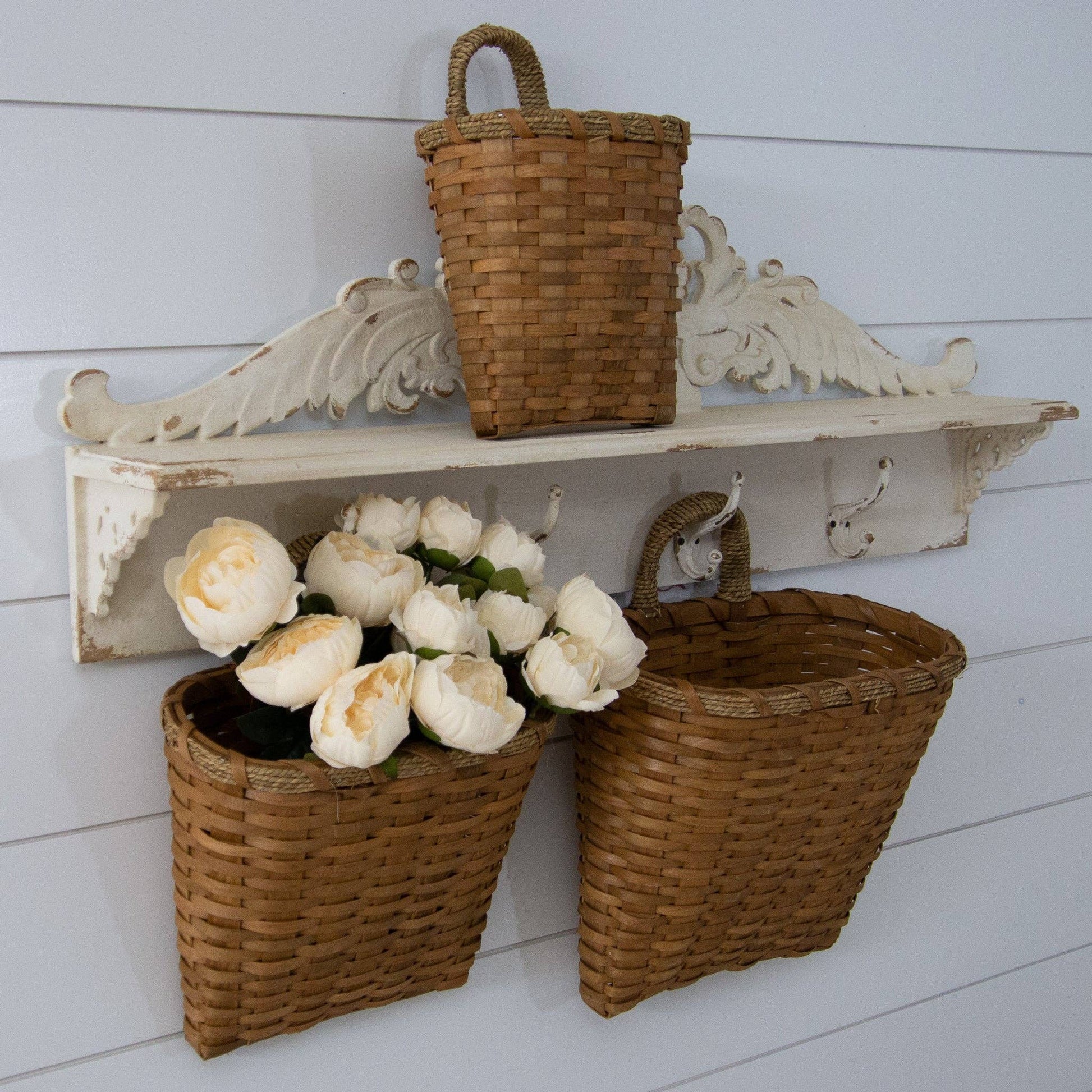 Rustic chipwood hanging baskets with woven handles, set of 3 in varying sizes. Perfect for wall decor and organizing essentials stylishly.