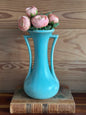 Vintage USA pottery vase in turquoise with a classic mid-century design, featuring elegant curved handles. Displayed with pink flowers on antique books.