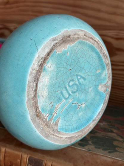 Bottom view of a vintage USA pottery vase in turquoise, showcasing its aged ceramic texture and 'USA' marking. A collectible mid-century home decor piece.