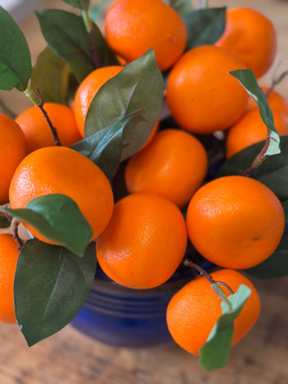 Close-up of artificial orange floral picks with realistic texture and green leaves. Ideal for adding a pop of color to any space.