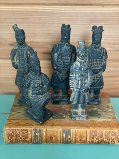 Terracotta warrior set featuring five vintage Chinese figures arranged on an antique book. Handcrafted and painted, perfect for historical home decor.