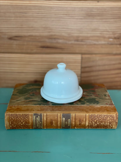 Vintage Pallet & Plate Butter Pad with a classic white ceramic dome lid, placed on an antique book. A charming addition to any rustic kitchen decor.