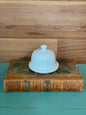 Vintage Pallet & Plate Butter Pad with a classic white ceramic dome lid, placed on an antique book. A charming addition to any rustic kitchen decor.