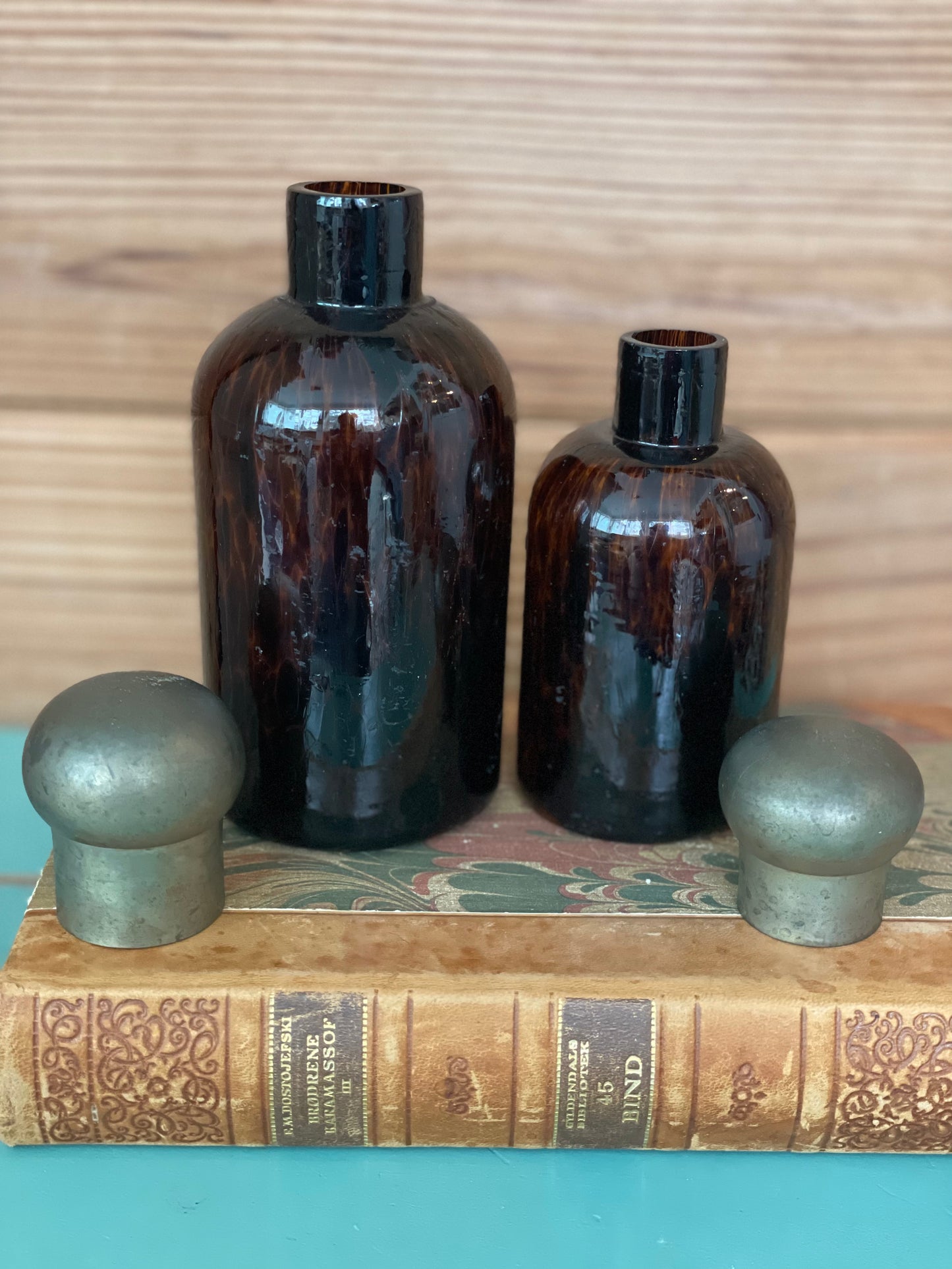 Set of two vintage tortoise glass bottles without lids, showcasing their rich amber hue. A stylish addition to any home decor collection.