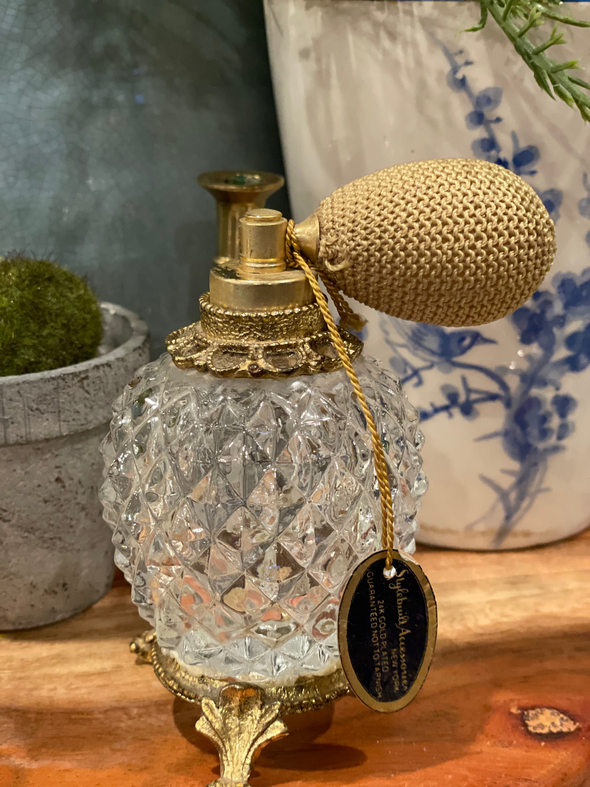 Vintage pedestal atomizer bottle with diamond point glass and gold-tone accents. Elegant mist delivery for perfumes, perfect for vanity decor.