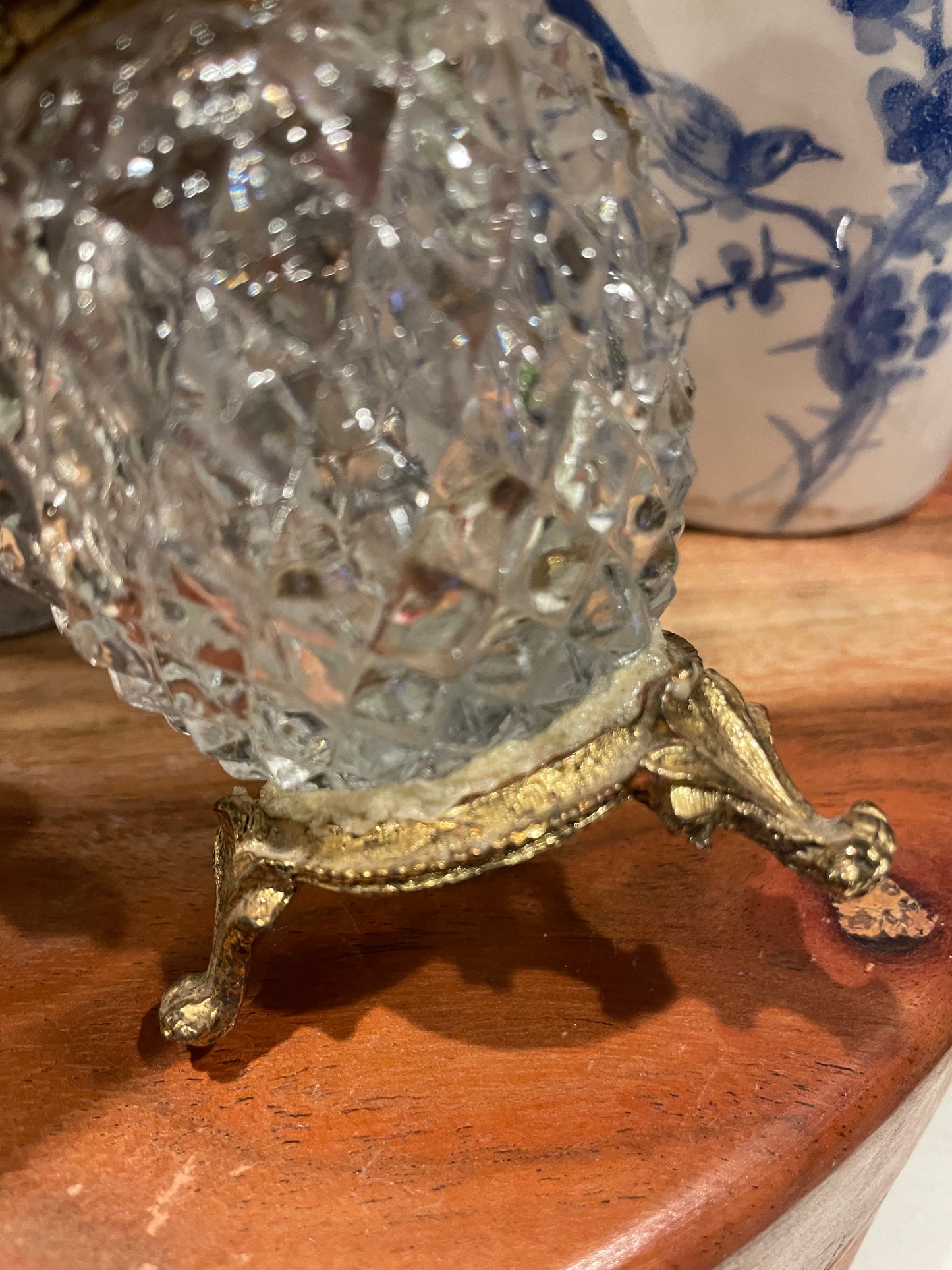 Detailed view of gold-tone pedestal base on vintage diamond point glass atomizer bottle. A charming addition to any vanity or decor collection.