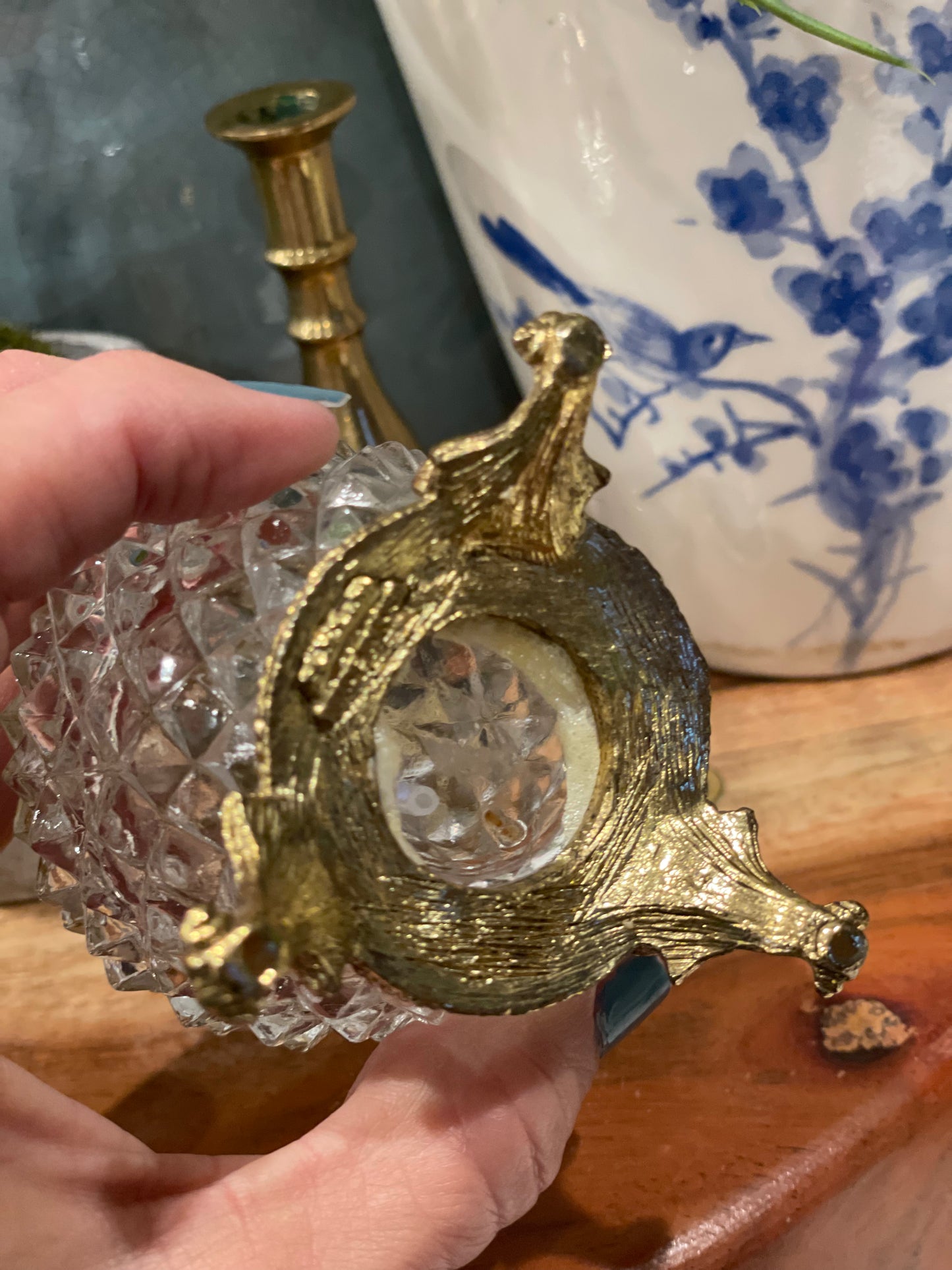 Bottom view of vintage pedestal atomizer bottle showcasing ornate gold-tone legs and diamond point glass design. Elegant and functional decor piece.