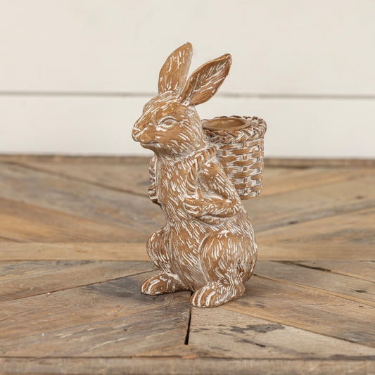 Bunny taper candle holder with a rustic finish, featuring a rabbit carrying a woven basket. Perfect for Easter and farmhouse-style decor.