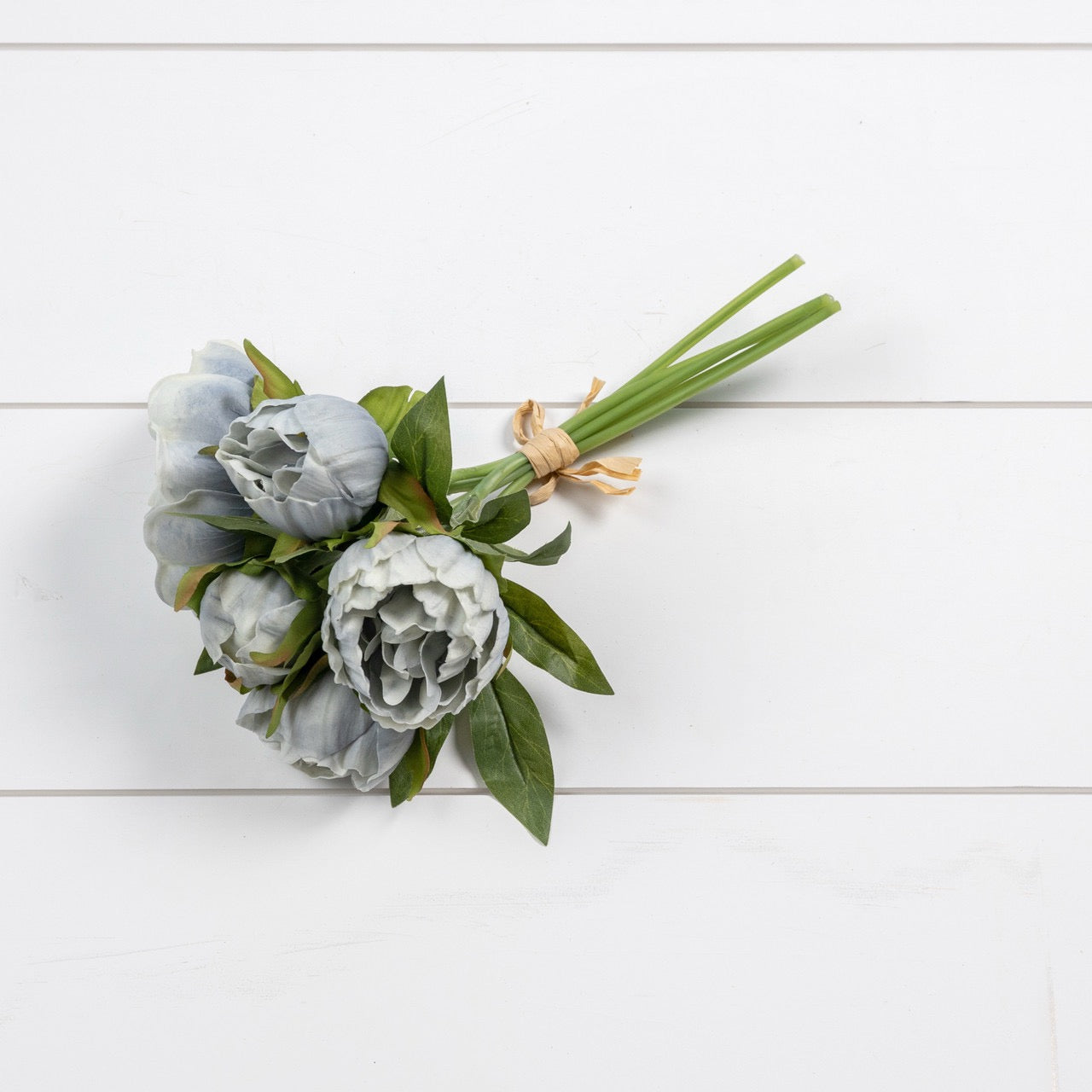 Lifelike Dusty Blue Peony Bundle tied with raffia, displayed on a white wooden surface. Perfect for bouquets, centerpieces, and timeless decor.