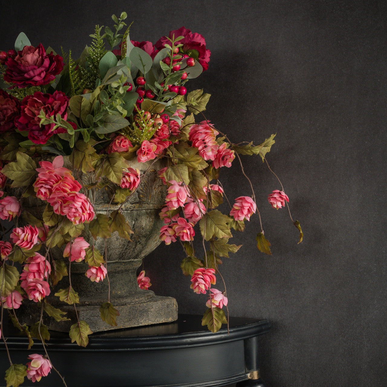 Elegant floral display with dark pink hops stem in a stone urn, enhancing home décor with a vintage and sophisticated aesthetic.