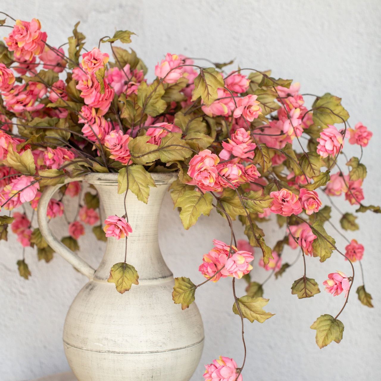 Rustic floral arrangement featuring 39-inch dark pink hops stem in a vintage white pitcher. Perfect for adding charm to home décor.