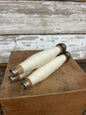 Set of three vintage wooden spools wrapped in cream yarn, featuring metal ends. Perfect for home decor or crafting projects.